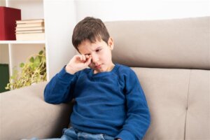 little boy rubbing his eye